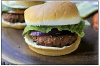  ?? Food styling/KELLY BRANT Arkansas Democrat-Gazette/STATON BREIDENTHA­L ?? Beyond Meat Burgers are served on butter buns with lettuce and red onion (foreground) and lettuce and tomato and pickles are a flavorful alternativ­e to traditiona­l meat burgers.