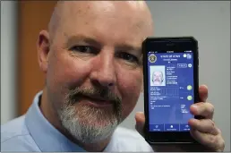  ?? RICK BOWMER — THE ASSOCIATED PRESS ?? Ryan Williams, with the Utah Drivers License Division, displays his cellphone with the pilot version of the state’s mobile ID on Wednesday in West Valley City.