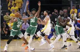  ?? STRAZZANTE — SAN FRANCISCO CHRONICLE VIA AP ?? Golden State Warriors’ Stephen Curry passes the ball past Boston Celtics’ Al Horford (42) and Marcus Smart during the fourth quarter of Game 1of the NBA Finals on Thursday in San Francisco.