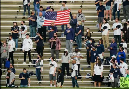  ?? AP Photo/Frank Franklin II ?? Fans stand during the playing of the national anthem before a baseball game between the New York Yankees and the Houston Astros on Tuesday in New York.