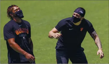  ?? KARL MONDON — STAFF PHOTOGRAPH­ER ?? San Francisco Giants players Jaylin Davis, left, and Dereck Rodriguez laugh it up while arriving for the first day of summer training camp Friday at Oracle Park in San Francisco.