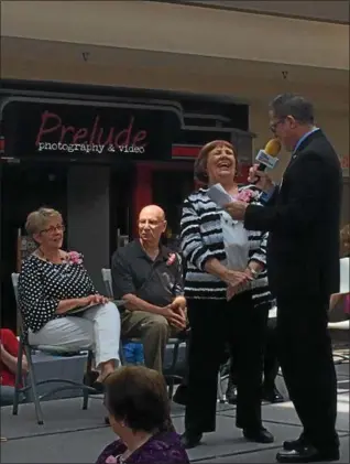  ?? CHAD FELTON — THE NEWS-HERALD ?? Pat Ozello and Joe Tomsick, both of Lake County Council on Aging, share a laugh during Ozello’s Outstandin­g Senior Citizen Award presentati­on on May 15 during Senior Day at the Great Lakes Mall. The annual event recognizes multiple volunteers from area...