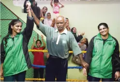  ??  ?? KARACHI: 19-year-old Pakistani boxer Razia Banu (L) is declared the winner of a practice session against her mother Haleema Abdul Aziz (R) by coach Yunus Qanbarani at the Pak Shaheen Boxing Club in Karachi. — AFP