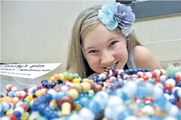  ?? BOB LIDDYCOAT/SPECIAL TO POSTMEDIA NEWS ?? Emily Mellish poses with a mound of jewelry she sells to raise funds for Shriners Children's Hospitals.