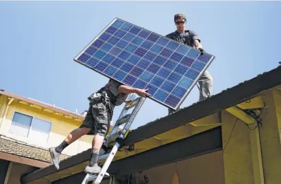  ?? Michael Noble Jr. ?? SunRun’s Brandon Anderson and Will LaRocque prepare to install a solar panel on a house in Sunnyvale, Calif.