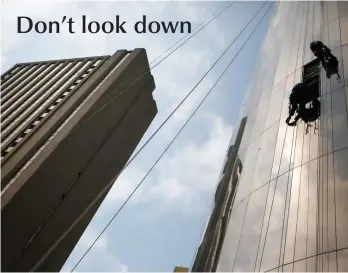  ?? PICTURE: EPA ?? HANGING AROUND: Two workers from SA Rope Access hang precarious­ly as they repair and clean windows on the side of a high-rise building in downtown Johannesbu­rg. The company specialise­s in window repairs, cleaning and other maintenanc­e needed on high...