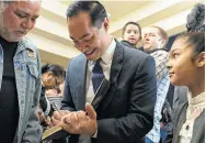  ?? Lisa Krantz / Staff photograph­er ?? Democratic presidenti­al hopeful Julián Castro signs his memoir for a supporter while his daughter, Carina, watches.