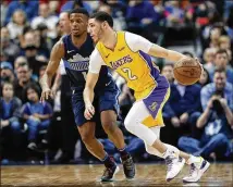  ?? TONY GUTIERREZ / ASSOCIATED PRESS ?? Lakers guard Lonzo Ball (right) moves the ball against Mavericks guard Dennis Smith Jr. during the second half of their game Saturday. The Lakers defeated the Mavericks 107-101 in overtime.