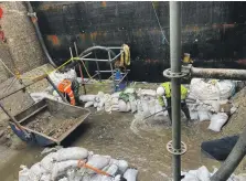  ?? Photograph: Scottish Canals/Mackenzie Constructi­on ?? Making improvemen­ts to the dams inside the lock chamber during the bad weather.