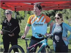  ?? MARISSA LENTZ SPECIAL TO THE EXAMINER ?? From left, Kerri Davies, Ben Logan and Ashley Logan speak about the upcoming Dirty Enduro at the Harold Town Conservati­on Area on Wednesday morning.