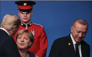  ?? (AP/Francisco Seco) ?? President Donald Trump talks with German Chancellor Angela Merkel and Turkish President Recep Tayyip Erdogan at a NATO leaders meeting in Great Britain in early December. The Pentagon announced plans Wednesday to move troops out of Germany, citing Germany’s lagging defense spending.