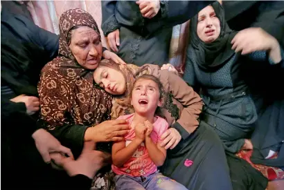  ?? — Reuters ?? Relatives of Palestinia­n haytham Al Jamal, 15, who was killed by israeli troops during protests at the israel-Gaza border, mourn during his funeral in Rafah in the southern Gaza Strip on Saturday.