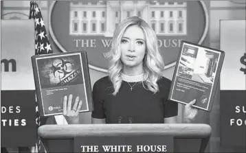  ?? DREW ANGERER/GETTY ?? White House Press Secretary Kayleigh McEnany holds up administra­tion pandemic plans Friday at the White House.