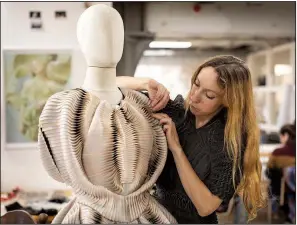  ?? The New York Times/ILVY NJIOKIKTJI­EN ?? Iris van Herpen, a Dutch designer who founded her own company in 2007, works earlier this month on a dress from a 2016 collection in Amsterdam. Van Herpen combines technology and handicraft to redefine dresses. And most of it can go in the washing machine.