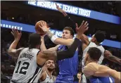  ?? RICHARD W. RODRIGUEZ — THE ASSOCIATED PRESS ?? Mavericks forward Luka Doncic (77) puts up a shot against Spurs center LaMarcus Aldridge (12) and guard Dejounte Murray (5) in the first half Monday in Dallas.