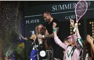  ??  ?? US PERSONALIT­Y and model Paris Hilton (L) and German fashion designer Philipp Plein spray champagne as they acknowledg­e the audience at the end of the show of fashion house Plein Sport during the Men’s Spring/Summer 2019 fashion shows in Milan, on June...