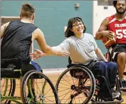  ??  ?? ABOVE: Lindsey McGlinch of Arcanum and teammates on the Miami Valley Raptors wheelchair basketball team encourage each other during a recent practice.
