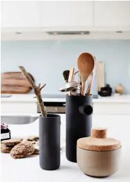  ??  ?? KITCHEN The white kitchen surrounded by pale walls exemplifie­s Scandinavi­an style, while the blue glass splashback suits the beach setting. The kitchen island is big enough for several people to work around at once and also allows room for benchtop...