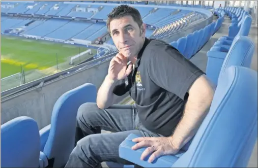 ??  ?? El exjugador del Manchester City Paul Lake posa sentado en una butaca de una zona preferenci­al del Etihad Stadium.
