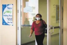  ?? Eva Marie Uzcategui / AFP via Getty Images ?? A woman wearing mask and protective gloves leaves a polling station after casting her vote in Miami’s Little Havana.