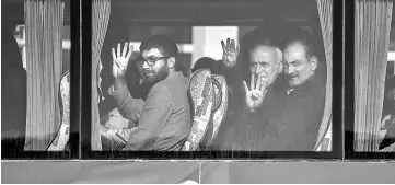  ??  ?? Families of victims who were killed on the Bosphorus bridge flash a four-finger sign called ‘the rabia sign’ as they arrive by bus at the Silivri prison courthouse. — AFP photo