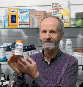  ??  ?? Marshall’s Health & Natural Therapy store manager Brent Wilson displays some of their serrapepta­se supplement­s. Serrapepta­se is a natural antiinflam­matory used to help treat a wide range of ailments.