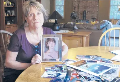  ?? DAVE COLLINS/AP ?? Linda Marino poses with photograph­s of her son, Samuel, at her home in Tolland. Samuel died in a 2009 car crash that relatives believe was intentiona­l after becoming a victim of a male sex traffickin­g ring. Advocates are calling for more services for male victims.