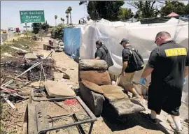  ?? Genaro Molina Los Angeles Times ?? LOS ANGELES homeless outreach team John Oliver, right, Jimmy Vasquez and Kim Barnett survey encampment­s along the 710 Freeway in Bell Gardens.