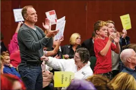  ?? KAREEM ELGAZZAR / THE CINCINNATI ENQUIRER VIA AP ?? Attendees react as Mason city council passed an ordinance criminaliz­ing abortions within the city limits, by a vote of four votes to three, Oct. 25, 2021, at Mount Washington Recreation Center in Cincinnati. It failed to pass as an emergency, meaning it won’t go into effect for 30 days.