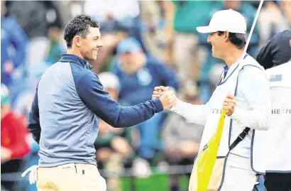  ??  ?? Rory McIlroy and caddy Harry Diamond celebrate after the Holywood star’s victory at Sawgrass