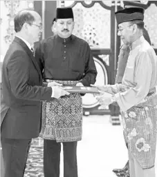  ??  ?? The Yang di-Pertuan Agong Tuanku Abdul Halim Mu’adzam Shah handing over appointmen­t letters to Datuk Wilfred Madius Tangau after being sworn in as the Minister of Science,Technology and Innovation at Istana Negara yesterday. - Bernama photo