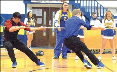  ?? Westside Eagle Observer/MIKE ECKELS ?? Taylor Haisman (right) and teammate Alex Lee try to hold their ground during the colors day pep rally’s seniorsoph­omore tug-of-war contest Dec. 15. Haisman’s right foot crossed the line, giving the victory to the sophomore class.