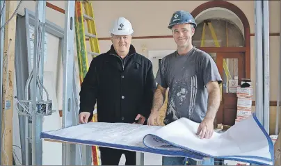  ?? JULIE COLLINS/CAPE BRETON POST ?? District 1 Coun. Clarence Prince looks over the plans for the renovation of the Old Post Office Tuesday with Brilun Constructi­on site foreman Angelo Canova. The heritage building in Sydney Mines is the future home of the Cape Breton Regional Police in North Division.