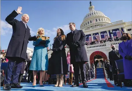  ?? ANDREW HARNIK / AP (POOL) ?? Joe Biden is sworn in as the 46th president of the United States by Chief Justice John Roberts as Jill Biden holds the Bible during the 59th Presidenti­al Inaugurati­on Wednesday at the U.S. Capitol. Watching at center are the Bidens’ children, Ashley and Hunter.