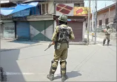  ?? — AFP photo ?? Indian paramilita­ry troopers stands guard in front of closed shops during a one-day strike in Srinagar.