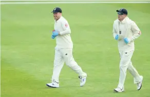  ??  ?? Dom Bess (right) and Matt Parkinson wear protective gloves whilst bringing supplies on to the field during the intra-squad match