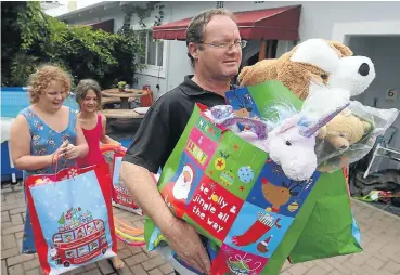  ??  ?? Bruce Done and daughters Keira-Leigh and Kendra donate toys and clothing they have collected for children hit by the Knysna fires.