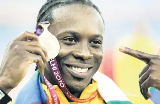  ?? FILE ?? Jamaica’s Lerone Clarke poses with his gold medal after he won the men’s 100 metres final at the 2010 Commonweal­th Games.