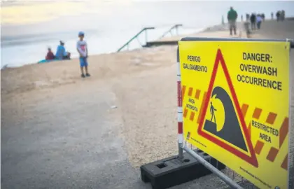  ?? Picture: AFP ?? HIGH WATER. A warning sign reading ‘Danger: overwash occurrence’ at Costa da Caparica, near Lisbon, on Saturday. Portugal placed most of the country on red alert because of storms.