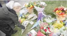  ?? — AFP ?? A Member of the public adds a bunch of flowers to floral tributes left at the scene of the fatal stabbing of Conservati­ve British lawmaker David Amess, at Belfairs Methodist Church in Leigh-on-sea, in southeast England.