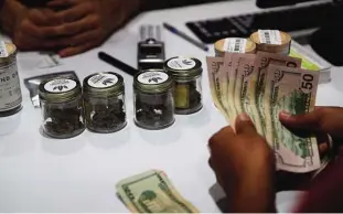  ??  ?? LAS VEGAS: A person buys marijuana at the Essence cannabis dispensary. —AP