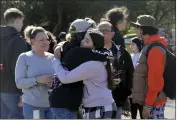  ?? BETH SCHLANKER — THE PRESS DEMOCRAT VIA AP ?? Cameron Gonzalez, 15, hugs fellow student Izzy Sullivan, 18, while Cameron’s mom, Amy Gonzalez, stands nearby a following a fatal stabbing at Montgomery High School in Santa Rosa on Wednesday. According to Gonzalez, her son and Izzy were in the office when a boy came in, said he had been stabbed, and then collapsed.