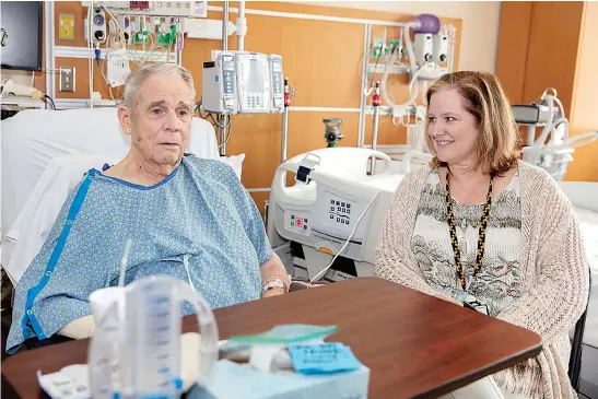  ?? Shawn Fury/VA Eastern Colorado Health Care System via AP ?? George Barrett, 85, of Lakewood, Colo., talks with geriatric nurse specialist Jennifer Franklin as he recuperate­s from open-heart surgery July 16 at the Rocky Mountain Regional VA Medical Center in Aurora, Colo. The hospital helped the American College of Surgeons test new standards to improve surgical care for older adults.