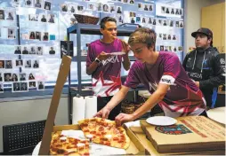  ??  ?? Ellis Holdren (left) and Aidan Hannigan grab a pizza lunch during a regional e-sports video game tournament at NBC studios.