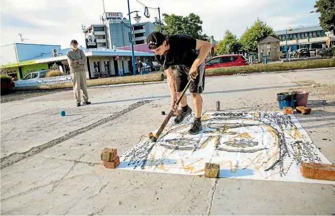  ?? PHOTO: DAVID JAMES PHOTOGRAPH­Y ?? Zakea Page at work. Music is always incorporat­ed into his performanc­es and a small speaker box blasted Kid Cudi nearby as he energetica­lly painted. Page’s grandfathe­r stands nearby watching proudly.