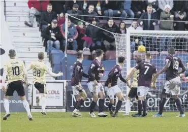  ??  ?? 2 Ryotaro Meshino, main image, is pursued by team-mates after scoring Hearts’ opener. 0 Above, Niall Mcginn curls in a free-kick for the equaliser following the dismissal of Sean Clare, inset far left.
2 Left, Daniel Stendel puts an arm around Aaron Hickey at full-time.