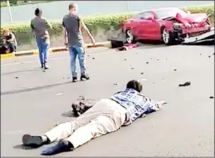  ??  ?? An injured person lies on the road at the site of the accident.