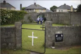  ?? NIALL CARSON — PA (VIA AP) ?? In this June 7, 2014, photo, members of the public visit the site of a mass grave for children who died in the Tuam mother and baby home, in Tuam, County Galway. Forensics experts say they have found a mass grave for young children at a former Catholic...