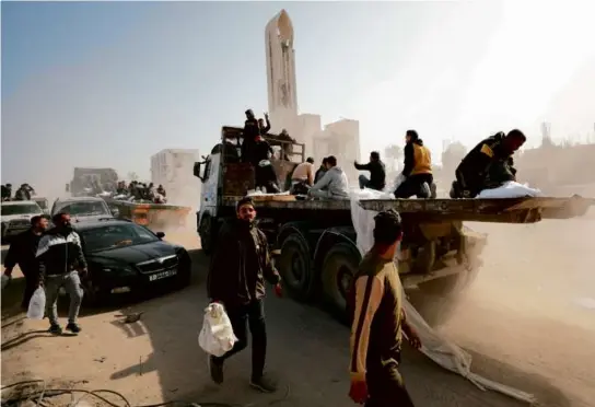  ?? AFP VIA GETTY IMAGES ?? Palestinia­ns transporte­d bags of flour on trucks as humanitari­an aid arrived in Gaza City on Wednesday.