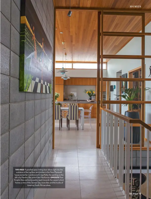  ??  ?? THIS PAGE A panelled glass sliding door allows light into the entrance of the top floor and kitchen in the New Plymouth house owned by Caroline and Craig Nolly; the painting on the left is by Hawke’s Bay artist Kate MacKenzie. OPPOSITE Poor Knights lilies and kentia palms reach towards the carport which frames a view of the Tasman Sea, more lilies and the trunks of towering South African aloes.